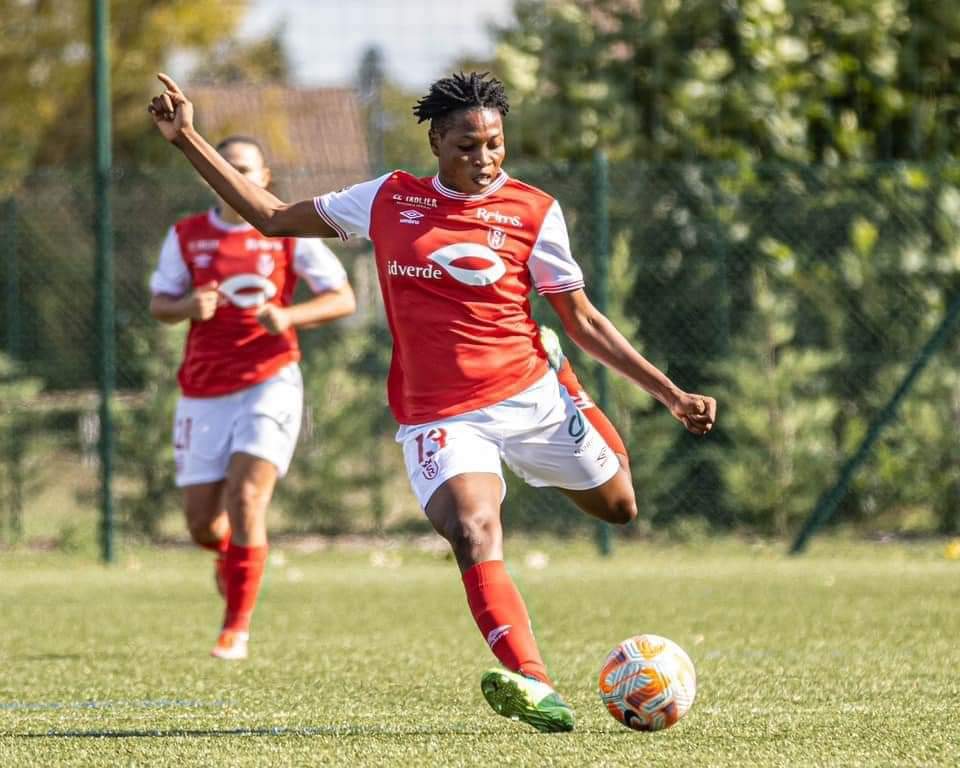 La joueuse de football Kethna Louis frappant le ballon sous les couleurs du Stade de Reims en D1 Arkema