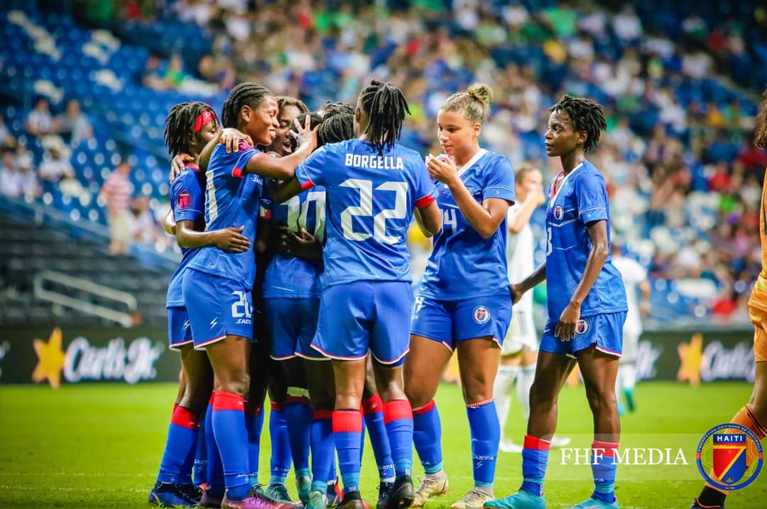 La selection haitienne de football feminine célébrant un but sur la pelouse